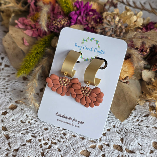 Embossed floral in muted burn orange with gold accent findings